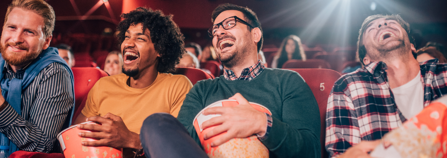 Group of men laughing in the cinema