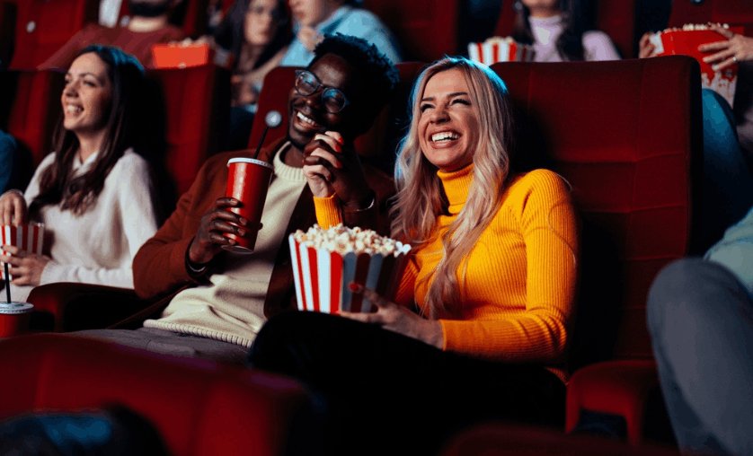 Woman sitting in cinema eating popcorn