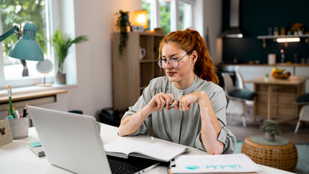 Young lady smiling, working at laptop