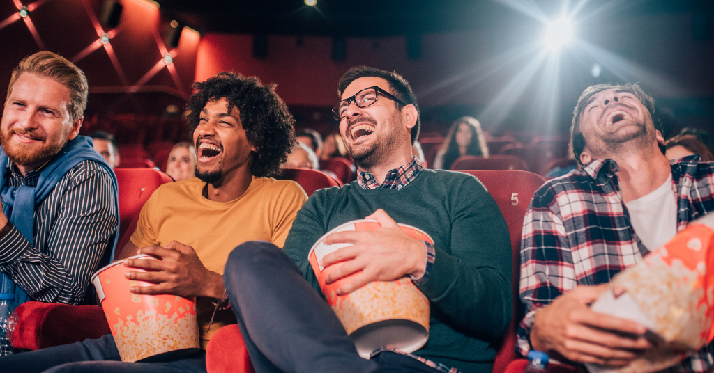 Group of young men laughing in a movie theatre